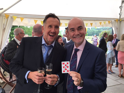 Two party guests holding a card